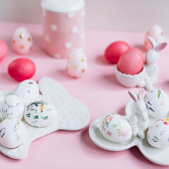 Easter composition with painted pink eggs and decorative figures with rabbits