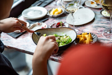 Fototapeta na wymiar woman hand eating salad in restaurant