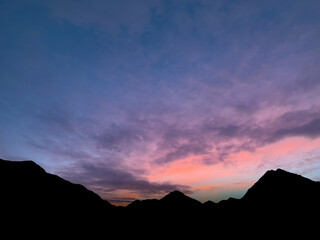 moody colored morning sky with mountain chains silhouette in tirol austria