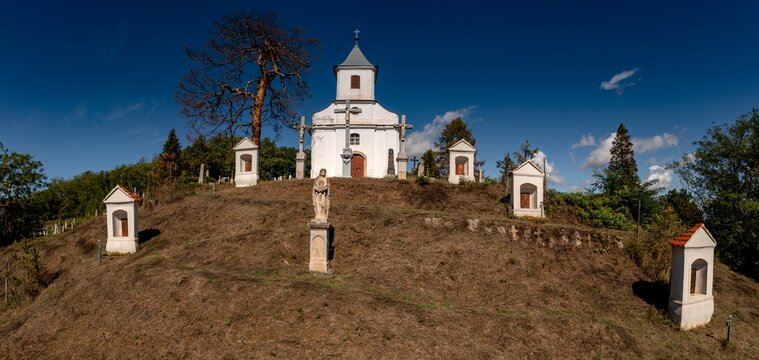 Small Christian chapel with graveyard on top of hill in Mecseknadasd, Baranya county, Hungary. Aerial drone photo.