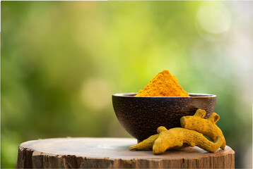 Turmeric or Indian turmeric rhizomes and powder on nature background.