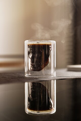 Black coffee in a skull-shaped cup, with a wisp of hot smoke rising from its surface.