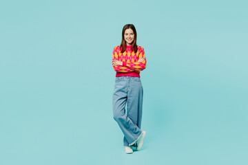 Fototapeta na wymiar Full body young smiling happy fun cheerful caucasian woman wear bright casual clothes hold hands crossed folded isolated on plain pastel light blue cyan background studio portrait. Lifestyle concept..