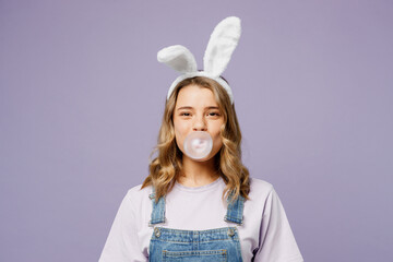 Young smiling woman wears casual clothes bunny rabbit ears inflate bubble gum chewing looking...