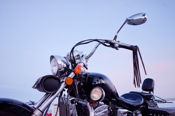Close up of classic black motorcycle with leather decoration outdoor.