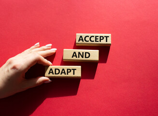 Accept or adapt symbol. Wooden blocks with words Accept and adapt. Beautiful red background....