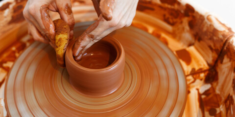 Master making a pot on pottery wheel, top view
