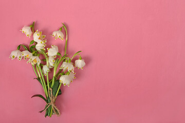 A bouquet of snowdrops on a pink background, Valentines day card, International Women\'s Day on March 8, Mother\'s day. Space for text.