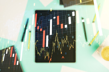 Abstract creative financial graph with world map and modern digital tablet on background, top view, forex and investment concept. Multiexposure