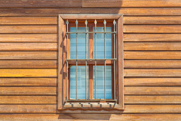 Fototapeta na wymiar Old traditional wooden window with wall made of wooden slats