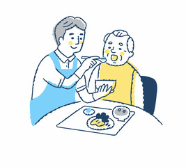 シニア男性の食事介助をしている介護スタッフ