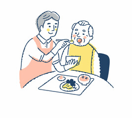 シニア男性の食事介助をしている介護スタッフ