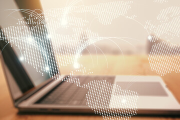 Double exposure of abstract digital world map with connections on laptop background, research and strategy concept