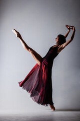 Half silhouette ballerina with a waving red dress. Elegant female ballet dancer.