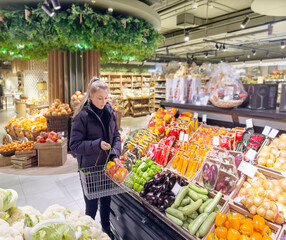 Woman buying vegetables(pepper, chili pepper, eggplant, zucchini) at the market