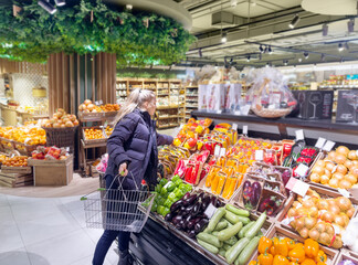 Woman buying vegetables(pepper, chili pepper, eggplant, zucchini) at the market