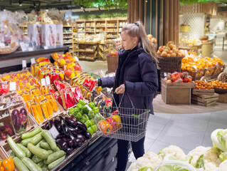 Woman buying vegetables(pepper, chili pepper, eggplant, zucchini) at the market