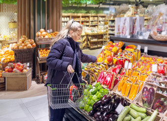 Woman buying vegetables(pepper, chili pepper, eggplant, zucchini) at the market