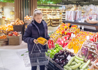 Woman buying vegetables(pepper, chili pepper, eggplant, zucchini) at the market