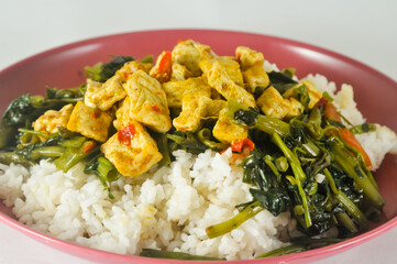 stir-fried water spinach with sliced tofu and white rice served on a red plastic plate