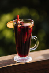Hot mulled wine in a glass with chopped fruits and star anise and cinnamon