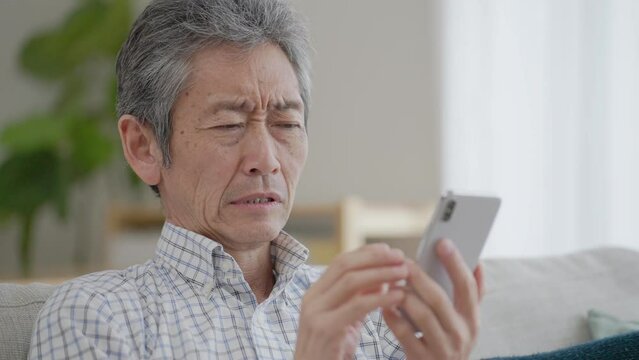スマホを使うシニア男性
