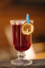 Red tea in a heat-resistant glass with a slice of dried orange