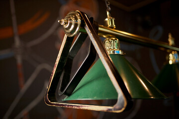 Lamps in the billiard club. Lamps above the billiard table shine in dark. Green billiard tables and...