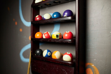 Billiard balls on a shelf, billiard balls for American billiard, colored billiard balls on a shelf in the closet. billiard balls for American pool on a shelf. Close-up photo. Soft focus.