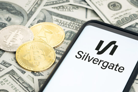 Galicia, Spain; january 28, 2022: Silvergate logo on Smartphone screen, dollar banknotes and crypto coins on table