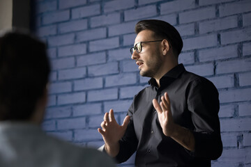Smart engaged handsome business leader man in glasses presenting project, idea for startup before...