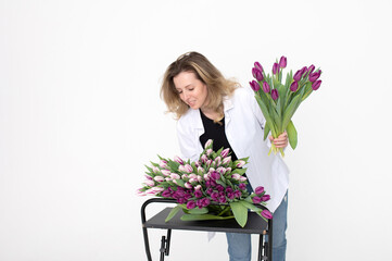 A sweet girl collected a bouquet of different varieties of tulips. Stands on a white background