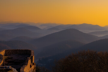 Sonnenaufgang und winterliche Hügellandschaft bei der Wegelnburg,  bei Schönau im Pfälzerwald in Rheinland-Pfalz, Deutschland, nahe der Grenze zu Frankreich. 