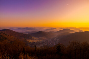 Sonnenaufgang und winterliche Hügellandschaft bei der Wegelnburg,  bei Schönau im Pfälzerwald in Rheinland-Pfalz, Deutschland, nahe der Grenze zu Frankreich. 