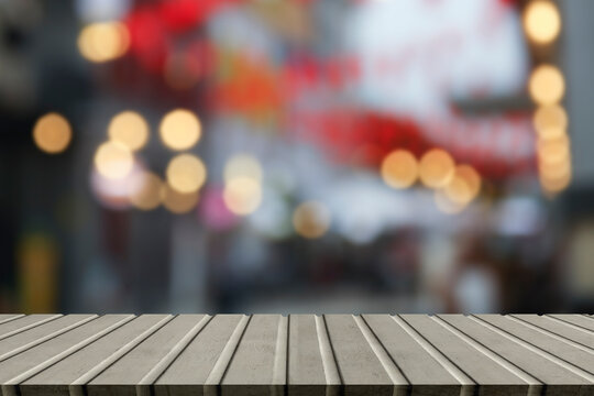 image of wooden table in front of outdoor abstract blurred background
