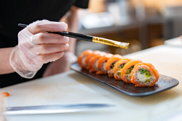 professional chef's hands making sushi roll in a restaurant kitchen