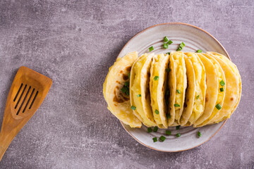Thin cakes filled with mashed potatoes with onions lie like a fan on a plate on a plate.