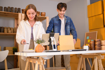 A young couple entrepreneur checking and packaging craft products selling to customers in them shop