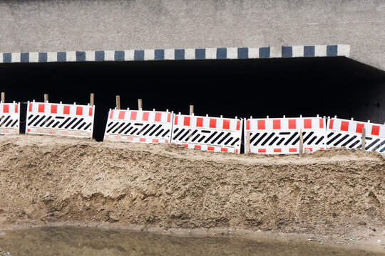 Closed tunnel background. Closed road barriers. Flooded road dangerous construction. Earthquake consequences landscape. Barrier made of sand. Muddy ground.