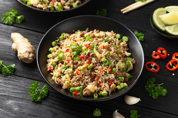 Asian Beef Fried Rice with eggs and vegetables in black bowl