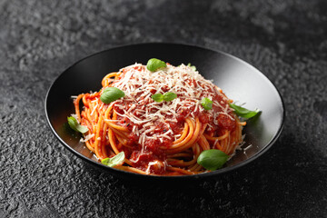 Italian marinara sauce spaghetti pasta served with fresh basil, olives and pecorino cheese