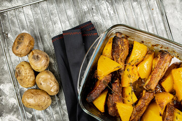 Baked pumpkin with pork ribs and baked potatoes on an abstract background, top view, baked vegetables with meat, flat lay.