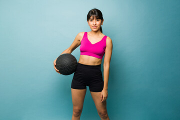 Sporty young woman with a slam ball exercising