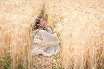 Beautiful Asian women were in white dresses relaxed and happy in the Barley rice fields season golden color of the wheat plant. Freedom traveler, dreamy portrait in a wheat field.