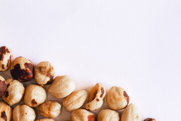 Peeled hazelnuts on a white background. Poorly peeled hazelnuts. Background of peeled hazelnuts.