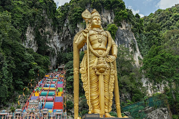 People visiting Batu Caves in Kuala Lumpur city. Giant Murugan statue at the entrance of Batu Caves, Malaysia