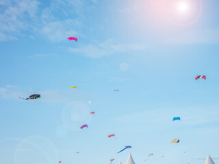 Colorful kites flying against the Windy weather is hobby in front of courtyard a blue sky at Kite Festival in satun , thailand