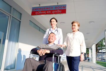 Naklejka premium Female doctor caring for elderly female patient sitting in wheelchair at hospital.