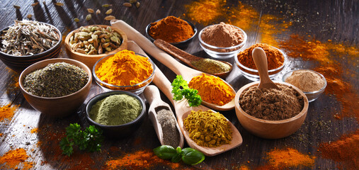 Variety of spices on wooden kitchen table.