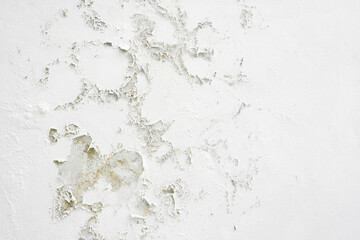 Closeup of badly fixed building facade wall covered with cracks in stucco and paint.